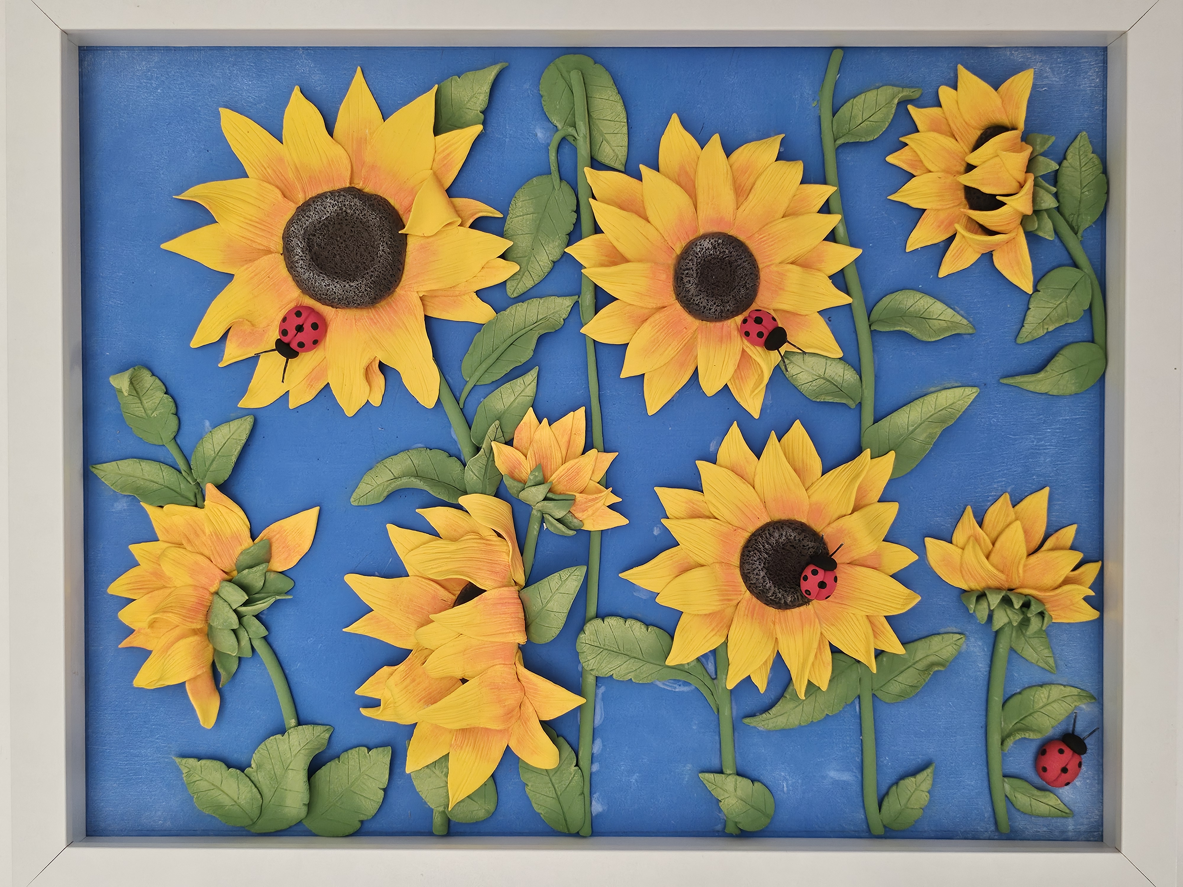 Sunflower relief panel with ladybugs on blue background